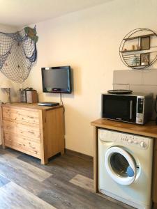Pokój z pralką i telewizorem w obiekcie Appartement vue mer le barcares w mieście Le Barcarès