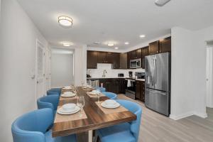 a kitchen with a wooden table and blue chairs at Newly Renovated Condo wFREE Resort Access in Orlando