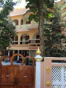 a building with a tree in front of it at Maharaju Palace in Kovalam