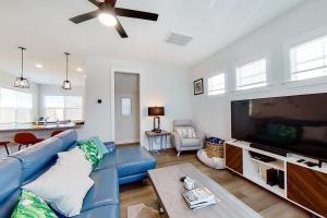 a living room with a blue couch and a flat screen tv at Downtown Jewel in Wilmington