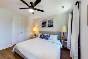 a bedroom with a white bed and a ceiling fan at Downtown Jewel in Wilmington