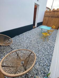 a patio with a table and chairs on top of gravel at Superbe appartement climatisé avec jardin entre mer et montagne in Anglet