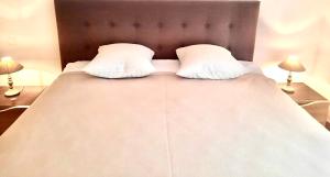 a bed with two pillows on it with two lamps at Orchid Luxury Suite Croisette Sea View Terrace 2 Bedr in Cannes