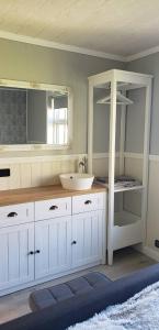 a white bathroom with a sink and a mirror at Pálshús in Patreksfjörður