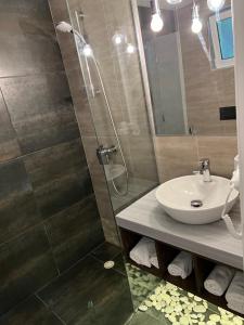 a bathroom with a sink and a shower at Kanes Boutique Hotel in Sarandë