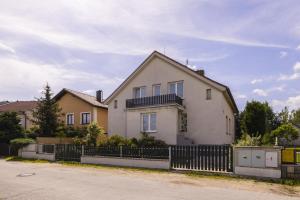a white house with a fence in front of it at Apartmány Na Obci Třeboň in Třeboň