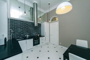 a kitchen with white cabinets and a black and white tile floor at VIP near Premier Palace & Arena city in Kyiv