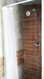 a bathroom with a shower with a shower curtain at Domek letniskowy SZARACZEK in Okuninka