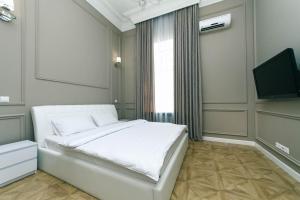 a bedroom with a white bed and a television at VIP near Premier Palace & Arena city in Kyiv