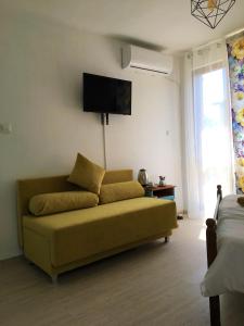 een woonkamer met een bank en een flatscreen-tv bij Стаи за гости Димитрови in Boergas