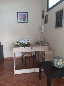 a white desk with a vase of flowers on it at La Cycas in Trabia +30 photos