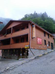 a large wooden building on the side of a street at Long Lake pansiyon in Uzungöl