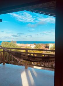 a hammock on a balcony looking out at the ocean at Loft Canoa in Aracati
