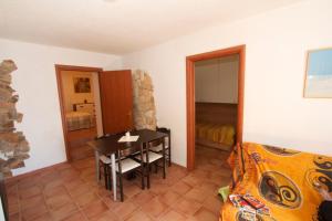 ブッジェッルにあるCasa Vacanze Mistralのテーブルとベッドルームが備わる小さな客室です。