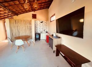 a living room with a television and a table and chairs at Loft Canoa in Aracati