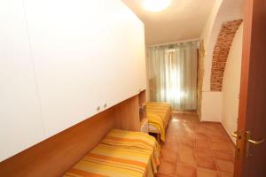ブッジェッルにあるCasa Vacanze Mistralのベッド2台が備わる小さな客室で、廊下があります。