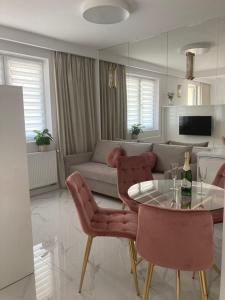 salon ze stołem, krzesłami i kanapą w obiekcie Apartamenty Parkowe B18 w Oświęcimiu