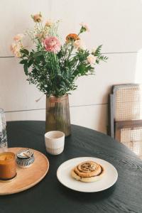 a table with a vase of flowers and a plate of food at Fejny Dom - Jezioro Dadaj in Kromerowo