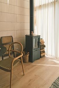 a living room with a chair and a stove at Fejny Dom - Jezioro Dadaj in Kromerowo