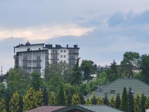ein großes weißes Apartmenthaus auf einem Hügel in der Unterkunft KLIF 2 Warka in Warka