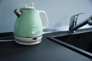 a green tea kettle sitting on a counter next to a sink at La dimora di Augusto in Rimini