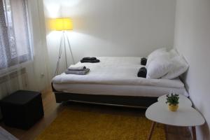 een slaapkamer met een bed met een lamp en een tafel bij Apartment KAPO in Sarajevo