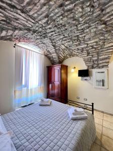 a bedroom with a large bed with a stone ceiling at La Vecchia Torre in Bosa