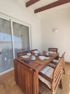 a wooden table with chairs and a dining room at Villa Coral in Cala'n Porter