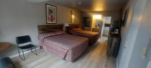 a hotel room with a bed and a chair at Lazy Bear Lodge in Cranbrook