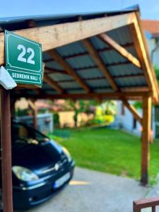 a car parked under a pergola with a sign at Apartman Amila in Sarajevo