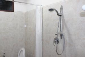 a shower in a bathroom with a toilet at Dangin Mangkalan Homestay in Munduk