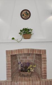 einen gemauerten Kamin mit Topfpflanze und Uhr in der Unterkunft Villa Coral in Cala en Porter