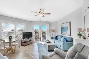 a living room with a blue couch and a tv at Gulfview II 318 in Destin