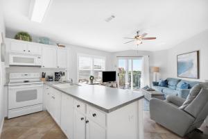 a kitchen with white cabinets and a living room at Gulfview II 318 in Destin
