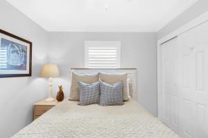 a white bedroom with a bed with blue and white pillows at Gulfview II 318 in Destin +27 photos