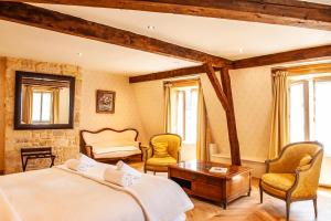 a bedroom with a bed and two chairs and a table at Les Cordeliers in Sarlat-la-Canéda