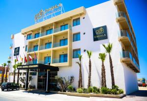 a hotel with palm trees in front of it at Dakhla Boarding Hotel & Restaurant in Dakhla