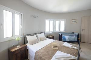 a bedroom with a large bed and windows at SAVINKA in Ancient Epidauros +28 photos