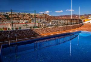 uma piscina de água com um campo de ténis em Blue Views Vivienda Vacacional em Puerto Rico de Gran Canaria