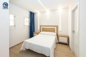 a white bedroom with a bed and a window at Apartamentos Marino Superior Casa Azahar in Alcossebre