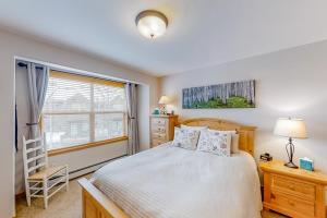 a bedroom with a bed and a chair and a window at Saw Mill Station 127 in Winter Park