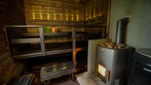 eine Küche mit einem Holzofen in einer Hütte in der Unterkunft Venejoen Piilo - Kuohu in Kontiolahti