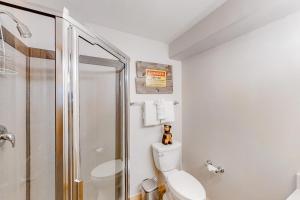 a white bathroom with a toilet and a shower at Saw Mill Station 127 in Winter Park +16 photos