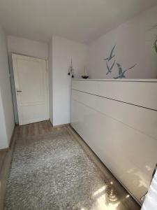 a room with a white wall and a door at Słonecznik Jastarnia. Domek na Zdrojowej. in Jastarnia +3 photos