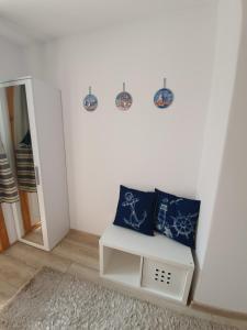 a white room with two blue pillows on a white wall at Słonecznik Jastarnia. Domek na Zdrojowej. in Jastarnia