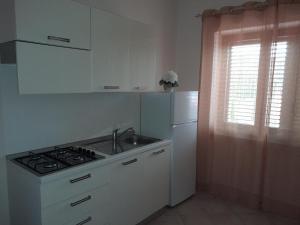 a kitchen with a stove and a sink and a refrigerator at B&B Gege' in Roccadaspide