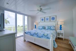 Un dormitorio blanco con una cama y un balcón. en Sandals D, en Sanibel 52 fotos más
