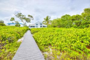 Un camino de madera a través de un campo con una casa al fondo. en Sandals D, en Sanibel