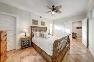 una camera da letto con un letto e un ventilatore a soffitto di Pipeline Manor a Port Aransas