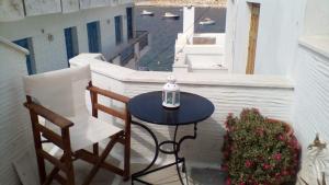 a table and chairs on a balcony with a view of the water at panormos studio in Panormos +11 photos